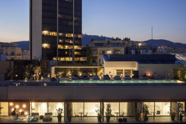 Ohla Eixample - a rooftop pool with a building in the background