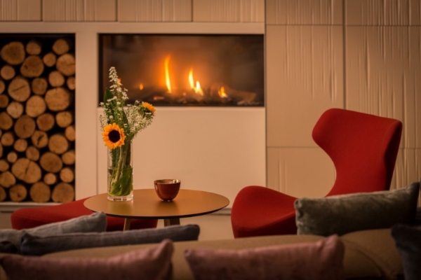 Ohla Eixample - a vase of flowers on a table in front of a fireplace