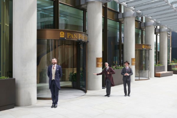 Pan Pacific London - a group of men in suits standing outside of a building