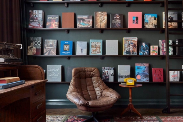 Pulitzer Amsterdam - a chair and a table with books on a shelf