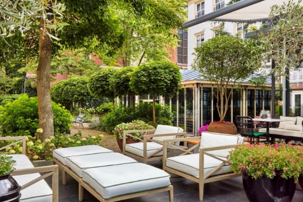 Pulitzer Amsterdam - a patio with white chairs and trees