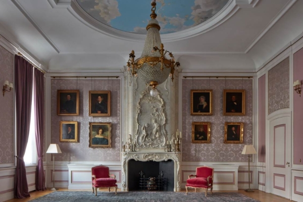 Pulitzer Amsterdam - a room with a fireplace and chairs