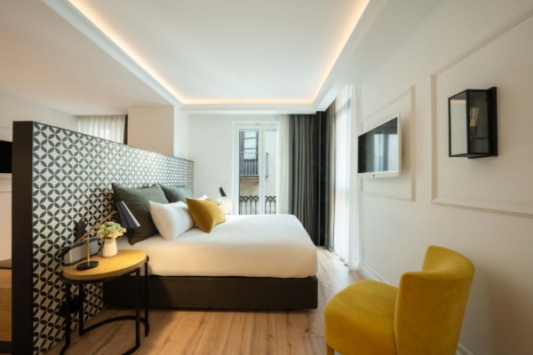 Serras Barcelona - a bedroom with a bed and a yellow chair