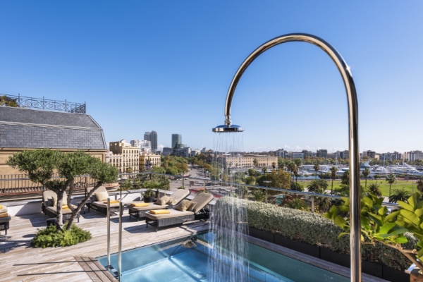 Serras Barcelona - a pool with a shower and a deck with a city in the background