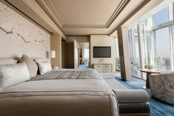 Shangri-La The Shard, London - a bedroom with a large bed and a television