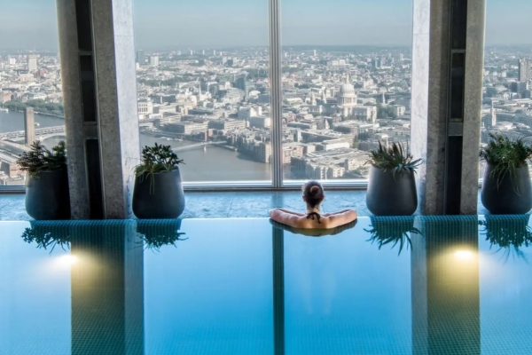 Shangri-La The Shard, London - a woman in a pool looking out a window