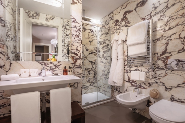 Singer Palace Hotel - Elegant marble bathroom with showe