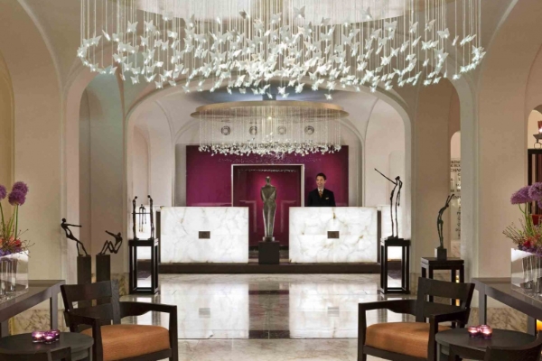 Sofitel Legend The Grand Amsterdam - a man standing behind a desk in a hotel lobby