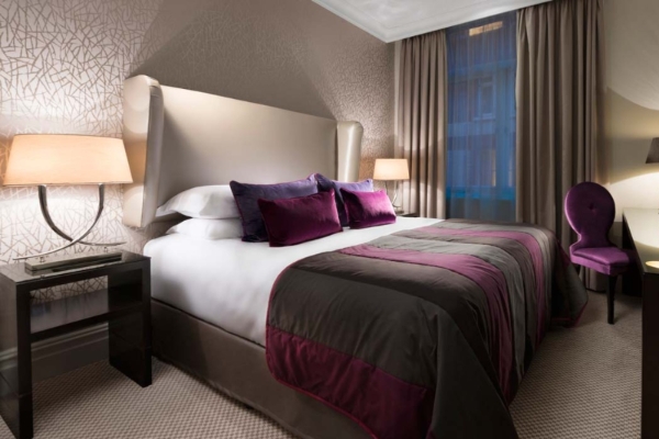 Taj 51 Buckingham Gates Suites and Residences - a bed with purple and white pillows