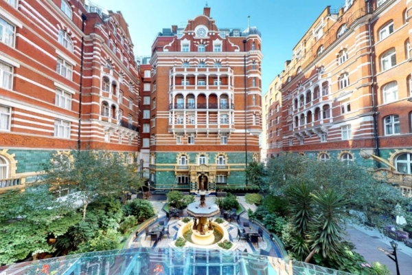 Taj 51 Buckingham Gates Suites and Residences - a courtyard with a fountain in front of a building