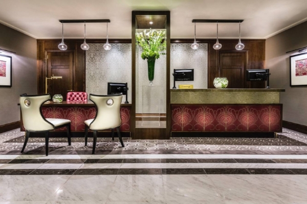 Taj 51 Buckingham Gates Suites and Residences - a reception area with a desk and chairs