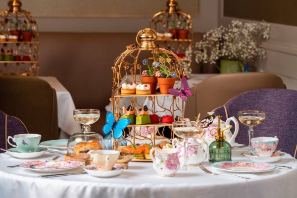 Taj 51 Buckingham Gates Suites and Residences - a table set with a bird cage and tea cups