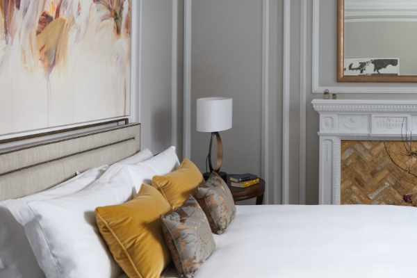 The Cadogan, A Belmond Hotel, London - a bed with pillows and a lamp in a room