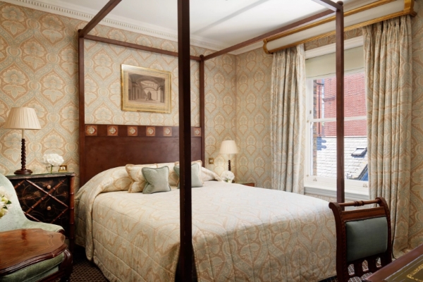 The Egerton House Hotel - a bed with a four poster bed