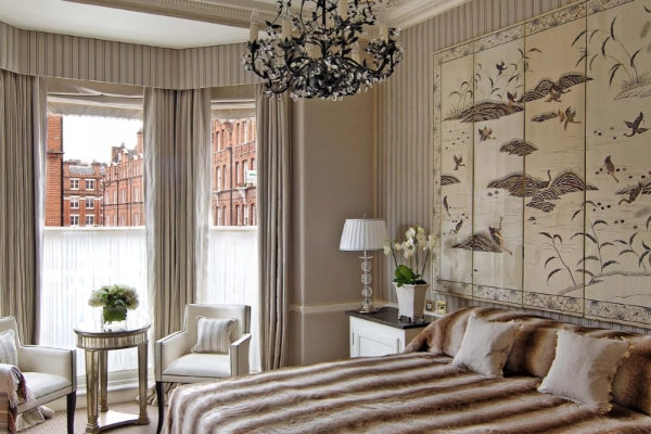 The Egerton House Hotel - a bedroom with a bed and a chandelier