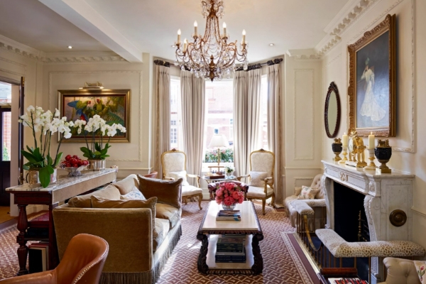 The Egerton House Hotel - a living room with a fireplace and chandelier