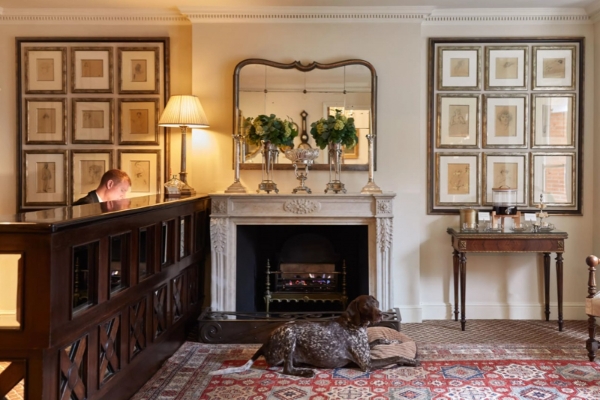 The Egerton House Hotel - a man sitting in front of a fireplace