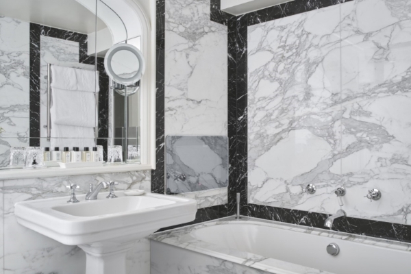 The Goring - a bathroom with marble walls and a sink