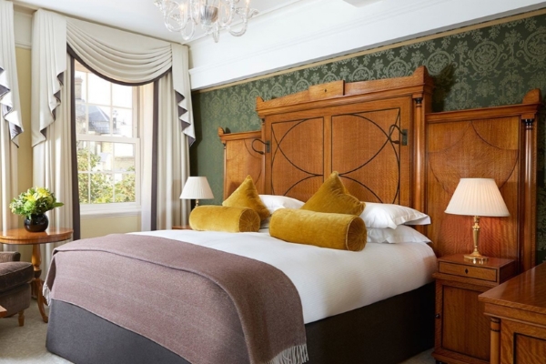 The Goring - a bed with pillows and a chandelier