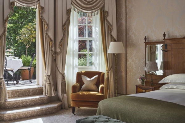 The Goring - a bedroom with a bed and a chair