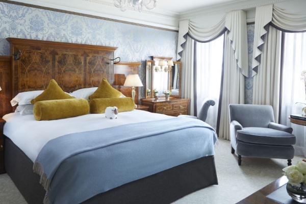 The Goring - a bedroom with a bed and a chair