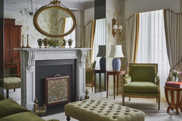 The Goring - a room with a fireplace and a green chair