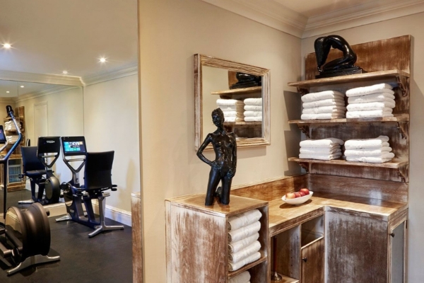 The Goring - a room with a mirror and a statue on shelves with towels