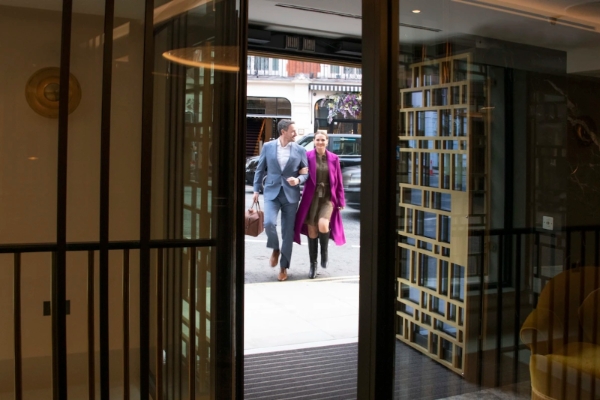 The Guardsman - a man and woman walking through a glass door