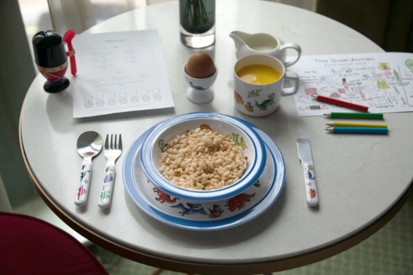 The Guardsman - a plate of cereal and a bowl of juice on a table