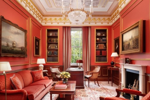 The Lanesborough - a living room with red walls and a chandelier