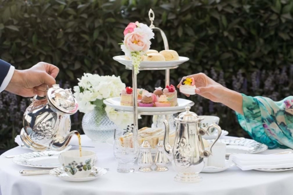 The Lanesborough - a man and woman pouring tea into a tray of food