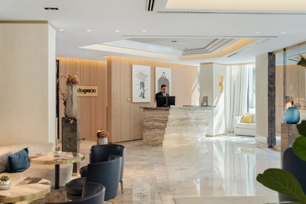 The One Barcelona - a man standing behind a desk in a hotel lobby