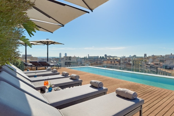 The One Barcelona - a pool with lounge chairs and umbrellas on a rooftop