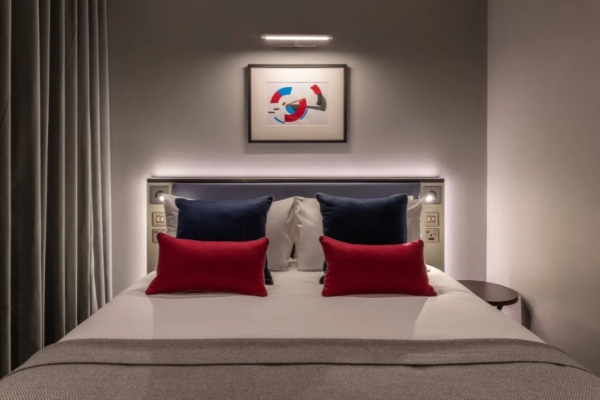 The Resident Covent Garden - a bed with red and blue pillows