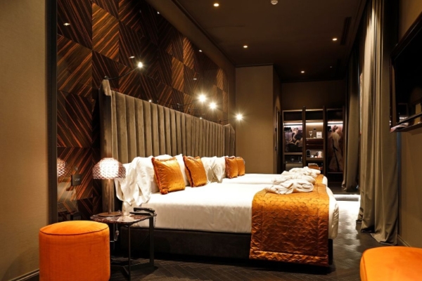 U-Visionary Roma Hotel - Contemporary hotel room with muted orange accents.