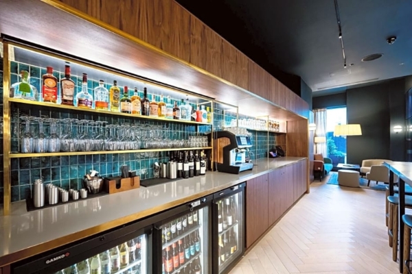 Wilde Aparthotels By Staycity London - Paddington - a bar with bottles and glasses on shelves