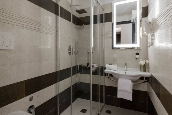 Yes Hotel Boutique Rome - Stylish tiled bathroom featuring an illuminated mirror and rainfall shower.