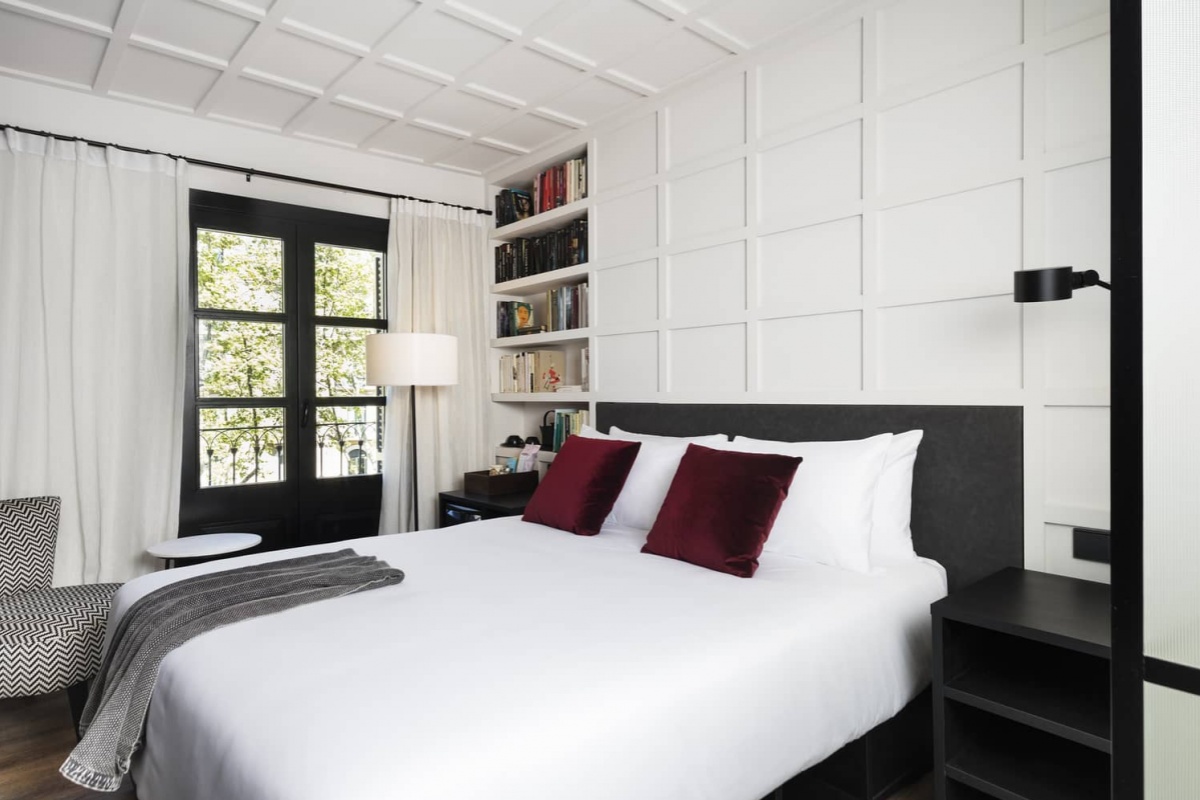 Yurbban Ramblas Boutique Hotel - a bed with red pillows and a lamp in a room
