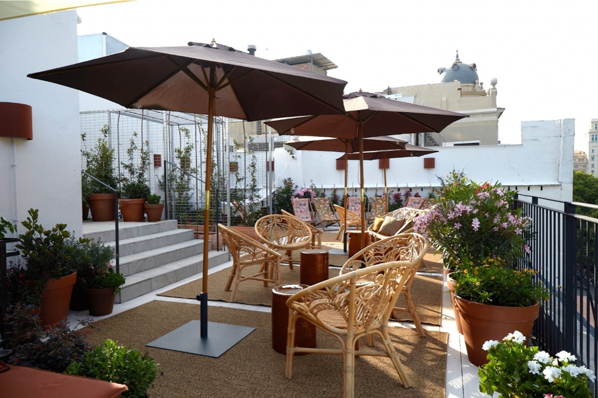 Yurbban Ramblas Boutique Hotel - a patio with chairs and umbrellas